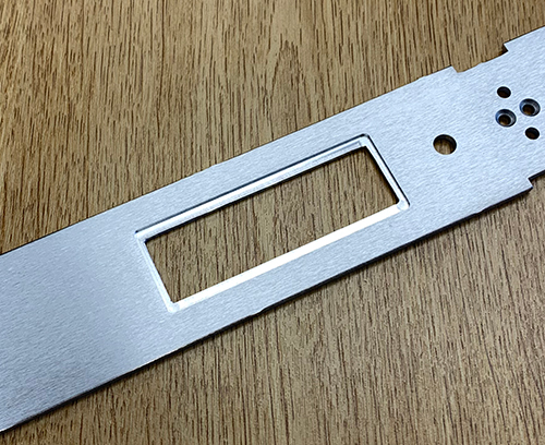 Recess machined into the rear side of a punched rectangular cutout for locating an display module.